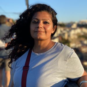 South asian woman with curly hair smiling